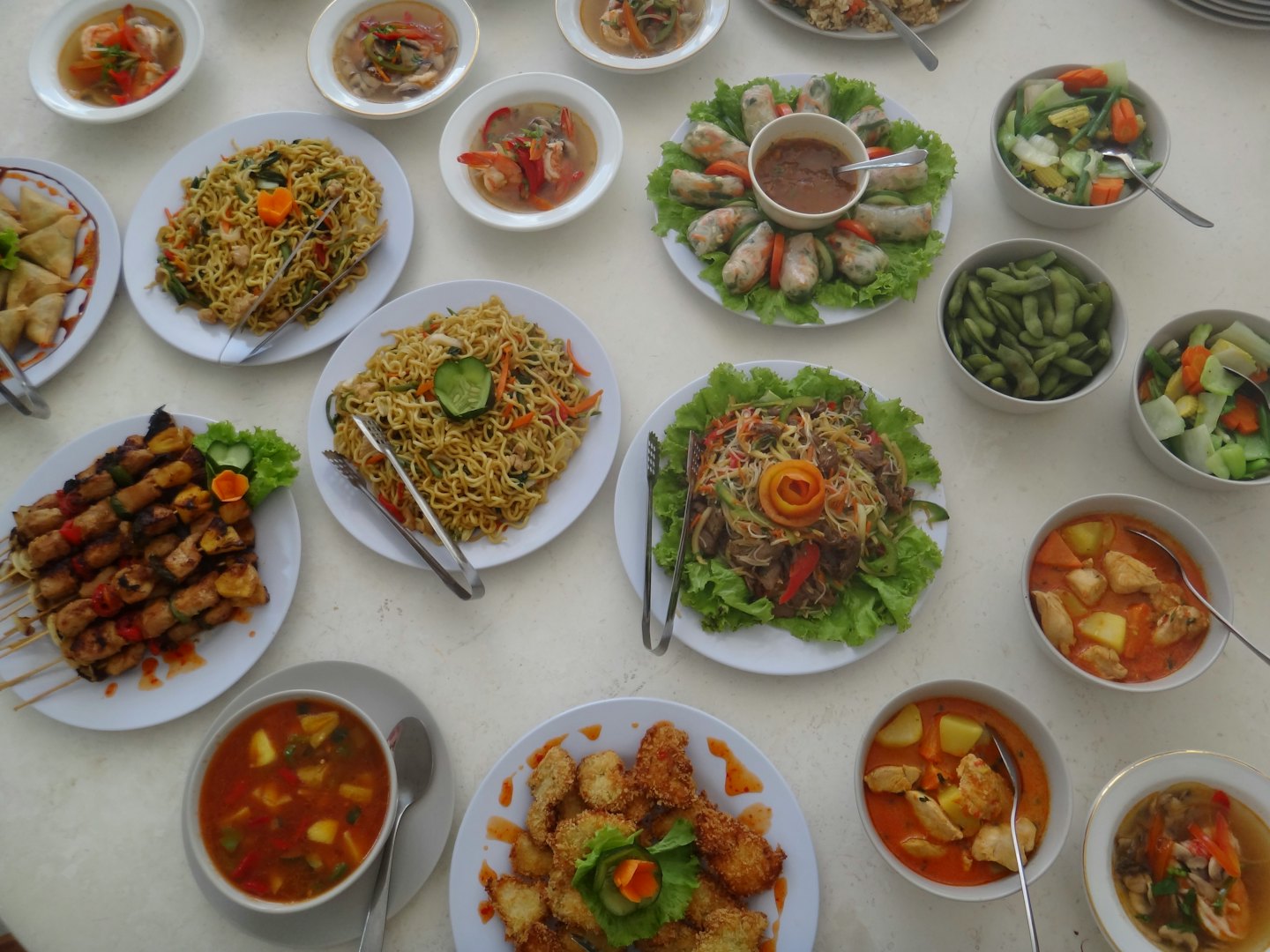 A table arranged with various Indonesian and Southeast Asian dishes.