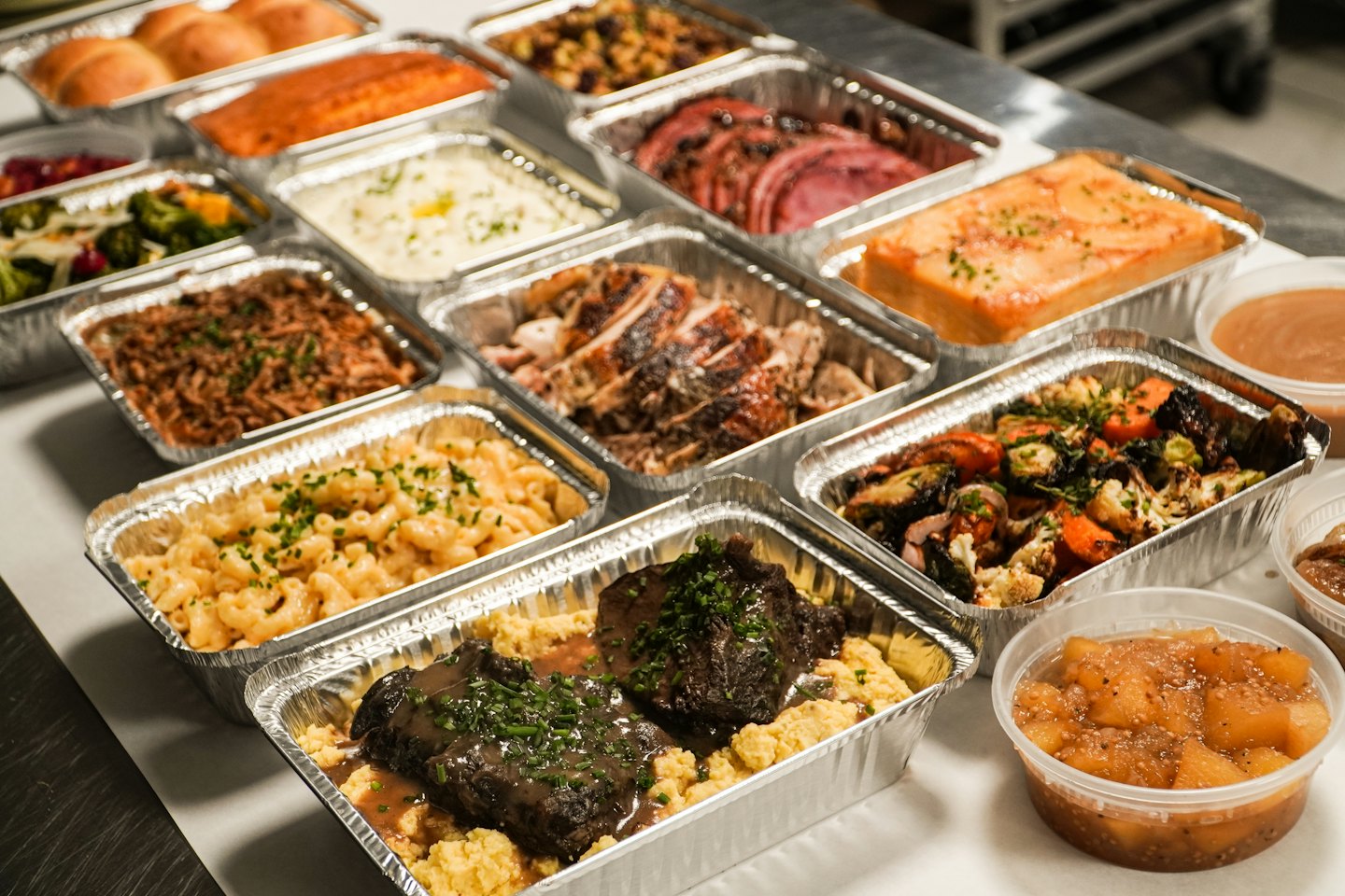Various pre-portioned meals in foil containers and plastic cups.